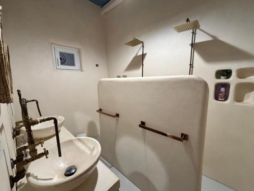 a bathroom with a sink and a white refrigerator at Casa Mediterranea Jacuzzi vista Mare Torre Guaceto Ostuni in Specchiolla 