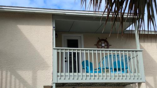a porch with two blue chairs on a balcony at Double Take! Renovated Vacation Home in Panama City Beach