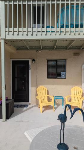 two chairs and a bird statue in front of a house at Double Take! Renovated Vacation Home in Panama City Beach