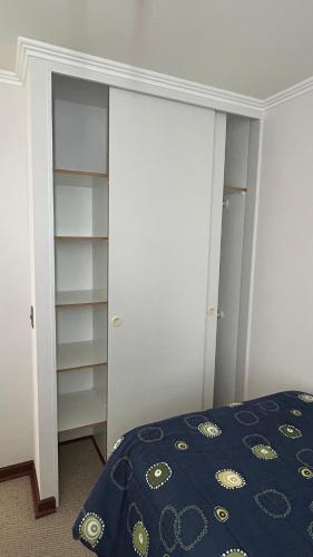 a bedroom with a bed and a closet at Habitación privada en Depto compartido in Iquique