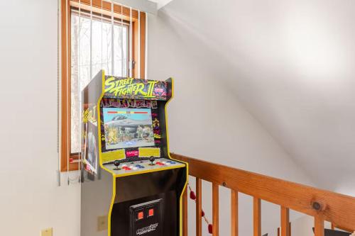 a pinball machine in a room next to a staircase at Cozy Cabin at Poconos With Hot Tub and Fire Pit in East Stroudsburg