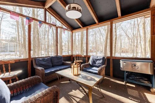a screened in porch with chairs and a table at Cozy Cabin at Poconos With Hot Tub and Fire Pit in East Stroudsburg