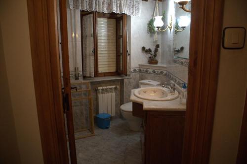 ein Badezimmer mit Waschbecken, Toilette und Spiegel in der Unterkunft Vivienda Quintana in La Cueva