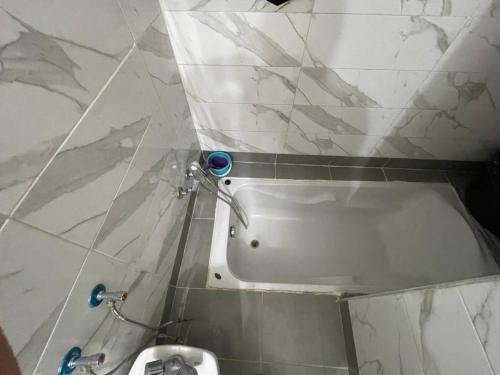 a bathroom with a bath tub in a tiled wall at Grand appartement fabuleux in Agadir