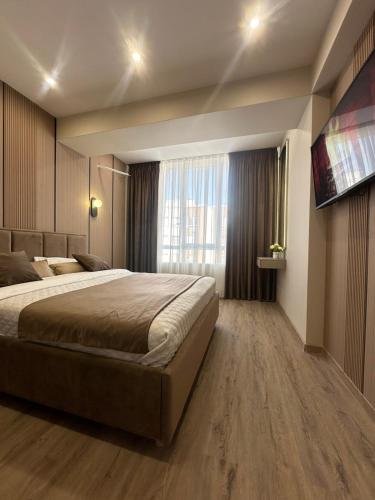 a bedroom with a large bed and a large window at Privat Apartment Ciocana in Chişinău