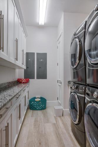 a laundry room with a washer and dryer at Luxury Beach Home, Gulf Access, Pool Table, Heated Pool & Spa - Summer Wind - Roelens in Fort Myers Beach