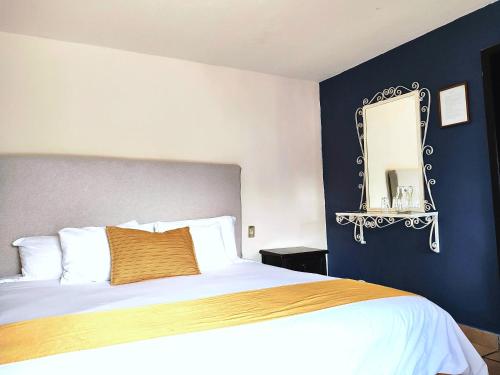 a bedroom with a large bed and a mirror at Hotel Jardines del Centro in San Cristóbal de Las Casas