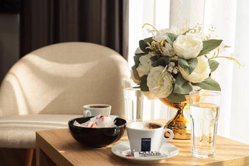 a table with a vase of flowers and a cup of coffee at Hotel Privé in Peje