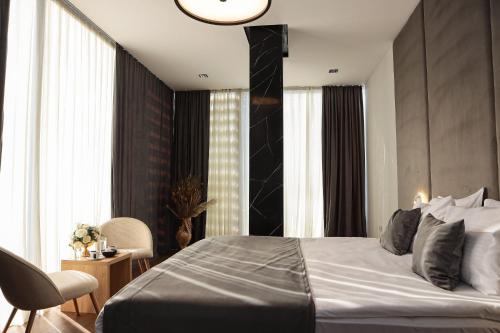 a bedroom with a bed and a table and chairs at Hotel Privé in Peje