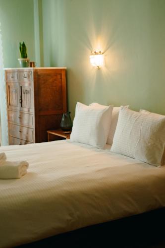 a bed with white pillows and a light on the wall at Timeless nest in Alexandroupoli
