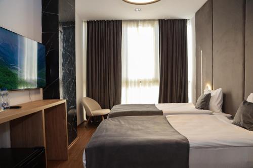 a hotel room with two beds and a window at Hotel Privé in Peje