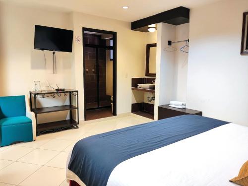 a hotel room with a bed and a tv at Hotel Jardines del Centro in San Cristóbal de Las Casas