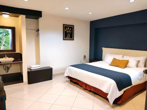 a bedroom with a large bed and a sink at Hotel Jardines del Centro in San Cristóbal de Las Casas
