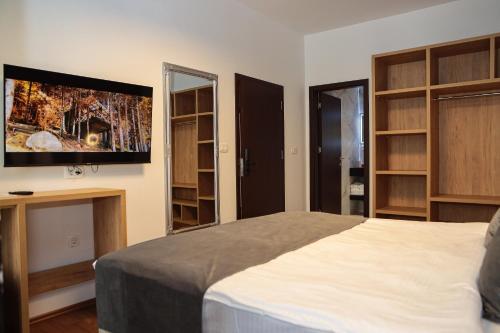 a bedroom with a bed and a tv on the wall at Hotel Privé in Peje