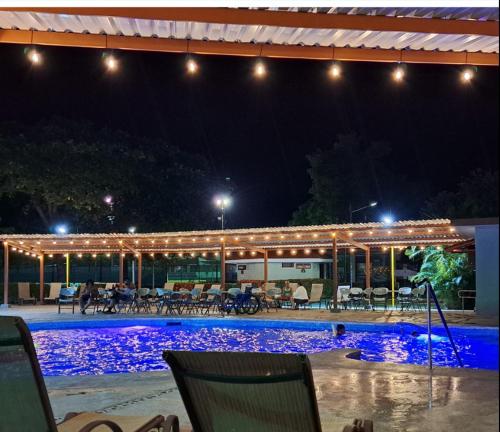 a swimming pool at night with lights on it at Nacazcol - Playas del Coco in Coco