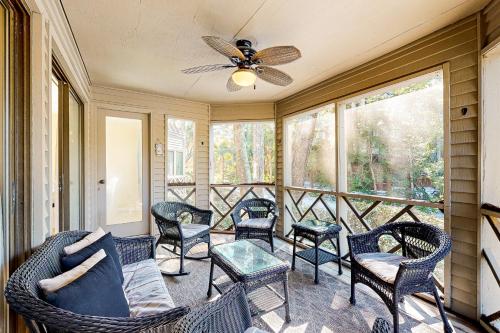 a screened in porch with chairs and a ceiling fan at Turtle Cove 4849 in Kiawah Island