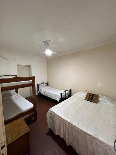 una camera da letto con due letti e un ventilatore a soffitto di Los Lirios Gardes Pehuajo a Pehuajó