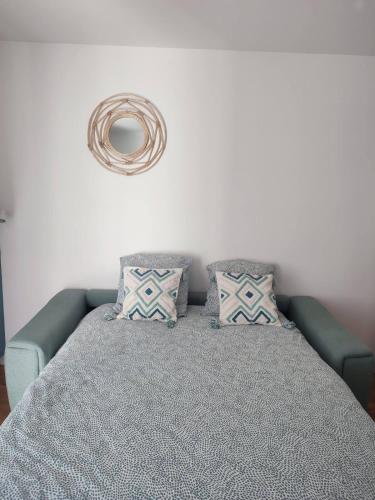 - un lit avec un canapé bleu et des oreillers dans l'établissement Petite maison avec jardin, Disney 15 min, Paris 25 min, à Thorigny-sur-Marne