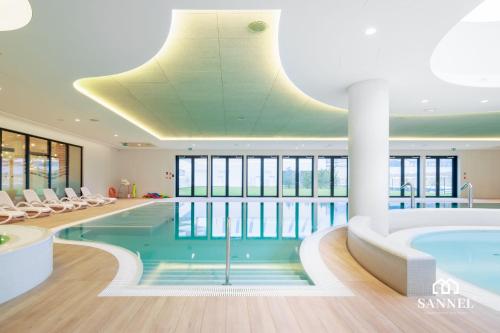una piscina en un hotel con un techo grande en Apartament Baltic Blues z dostępem do basenów,strefy saun,jacuzzi - Pinea Apartments Pobierowo - SANNEL Apartments for rent, en Pobierowo