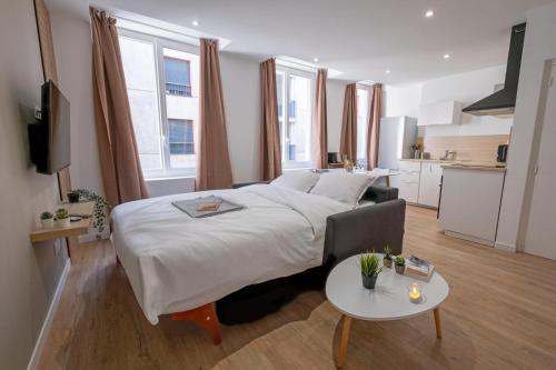 une chambre avec un grand lit et une table dans l'établissement Neuf & cosy, Centre-Ville, Netflix, à Saint-Étienne