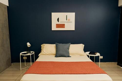 a bedroom with a bed with a blue wall at Apartahotel Poblado-Aguacatala in Envigado