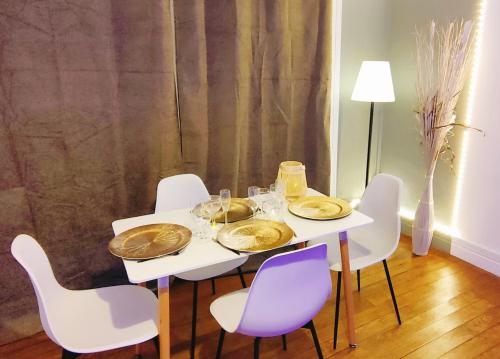 - une table blanche avec des chaises et des assiettes blanches dans l'établissement 150m plage COEUR DE BERCK, à Berck-sur-Mer