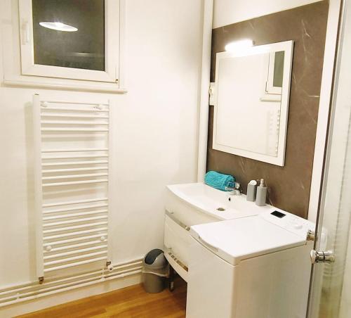 une salle de bain avec un lavabo blanc et un miroir dans l'établissement 150m plage COEUR DE BERCK, à Berck-sur-Mer