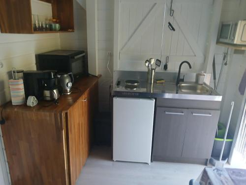 a small kitchen with a sink and a stove at Bungalow Lolo Moringa in Bouillante