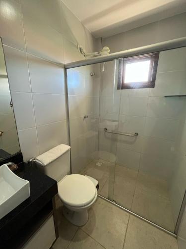 a bathroom with a shower and a toilet and a sink at Pousada Aconchego in Pitimbu