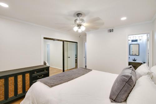 卡森10 Mi to Redondo Beach Carson Home with Pool Table!的一间带床和吊扇的白色卧室