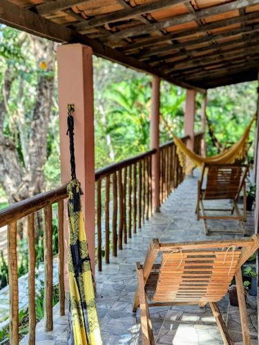 a porch with two chairs and a hammock on it at Casa das Irmãs - Só Mulheres - Women Only in Vale do Capao