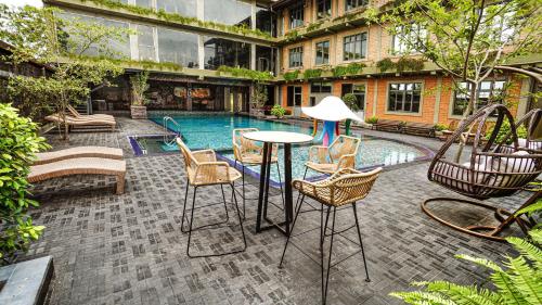 a patio with a table and chairs next to a pool at Sasha Transit Hotel in Katunayake