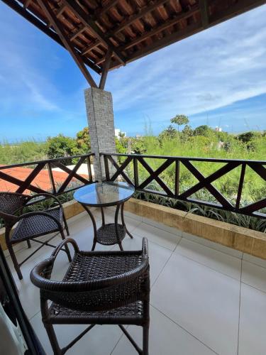 a patio with chairs and a table on a balcony at Pousada Aconchego in Pitimbu