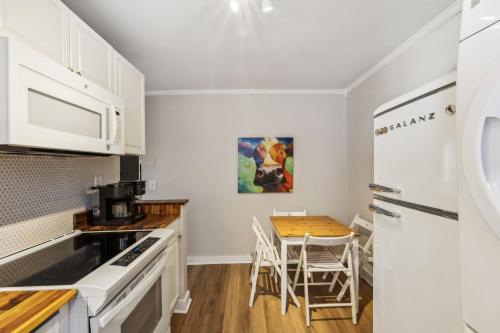 a kitchen with white cabinets and a table with chairs at Sunny Delight in Nashville