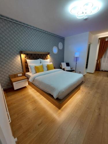a bedroom with a large bed with yellow pillows at ONYX - Vision Aparthotel in Braşov