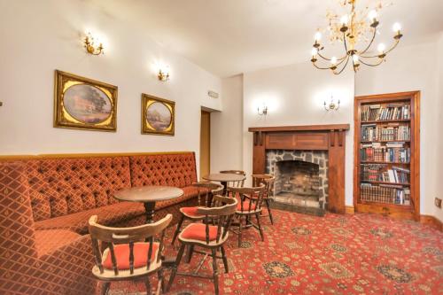 a living room with a couch and tables and a fireplace at White Waters Hotel in Llangollen