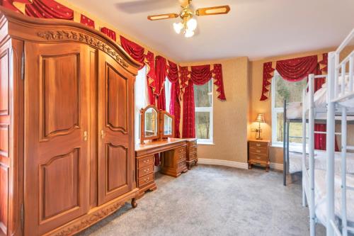 a bedroom with a large wooden wardrobe and bunk beds at White Waters Hotel in Llangollen