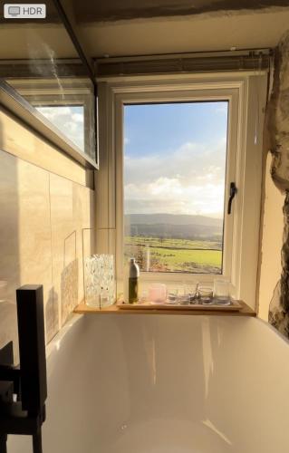 a bathroom with a large window and a bath tub at Luxury Retreat in Embsay