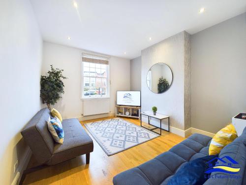 a living room with a couch and a tv at 2 Bed Ensuite, Secure Parking, Fast WiFi & SmartTV in Derby
