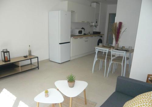 - un salon avec un réfrigérateur blanc et une table dans l'établissement Appartement T2 cosy à colomiers, à Colomiers