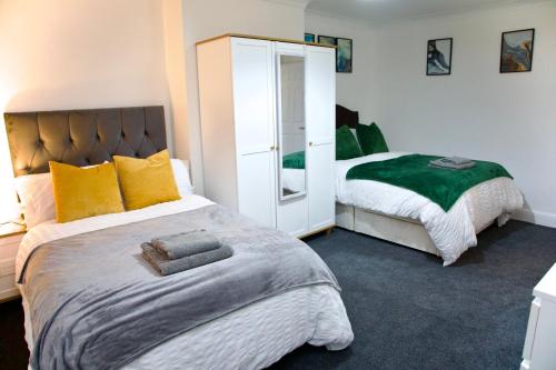 a bedroom with two beds and a mirror at Cosy & Stylish 2 Bed Ground Floor Flat in Dartford in Dartford