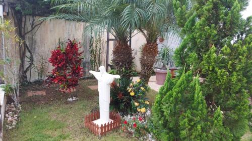 a garden with a statue of a cross in the yard at Casa Santo Sossego in Peruíbe