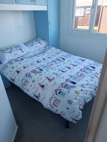 a bed in a room with a bedspread with cars on it at Chalet 281 Golden Sands Holiday Park in Withernsea