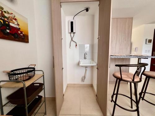 a small bathroom with a sink and two stools at Cálido mini apartamento in Manizales