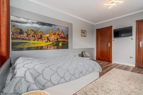 a bedroom with a bed and a painting on the wall at Willa Jaś I Małgosia in Kościelisko