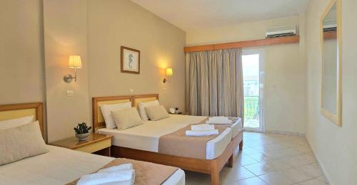 Postel nebo postele na pokoji v ubytování Koulouris Beach Hotel
