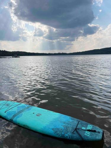 a blue surfboard in the water on a lake at The Luxe Lodge in Algonquin Highlands