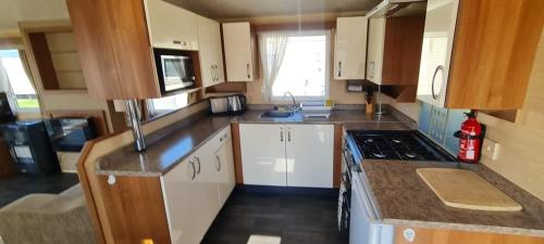 a kitchen with white cabinets and a stove top oven at 3 bedroom in Meliden
