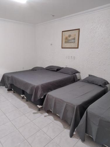 two beds are lined up in a room at Hotel Recanto da lagoa in Juazeiro do Norte