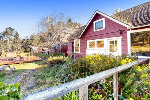 ein rosa Haus mit einem Holzzaun im Hof in der Unterkunft Big River Retreat in Mendocino